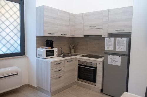 罗马DOMVS Ginori Testaccio的厨房配有白色橱柜、水槽和微波炉
