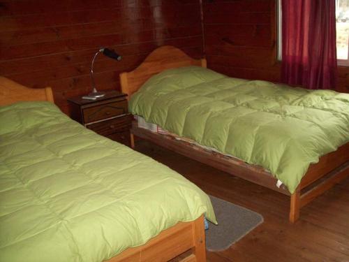 圣安东尼奥Hosteria Algarrobo的两张睡床彼此相邻,位于一个房间里