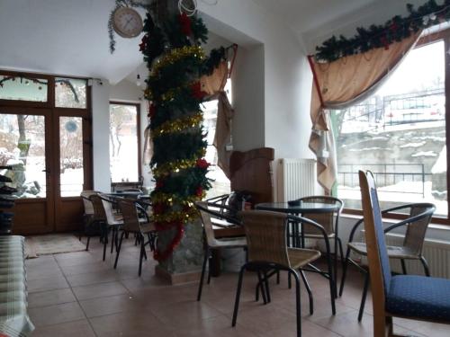 Crni VrhVila Dukat Stara Planina的一间餐厅,配有桌椅和圣诞树