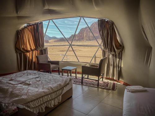 瓦迪拉姆RUM ROYAL FLOWER lUXURY CAMP的卧室设有窗户,享有沙漠美景
