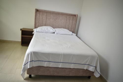 巴耶杜帕尔Casa Campo Villa Rosa的卧室内的一张带白色床单和枕头的床