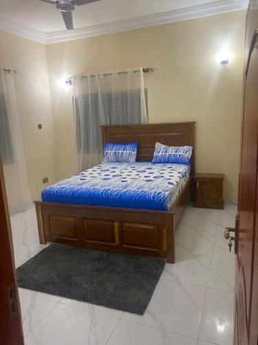 BurengTwo bedroom apartment Paradise estate Apt的一间卧室配有一张带蓝色床单和枕头的床。