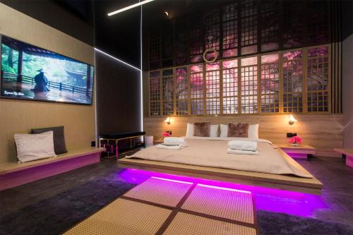 格但斯克Grey Aqua Secret Apartament的一间卧室配有一张紫色灯大床