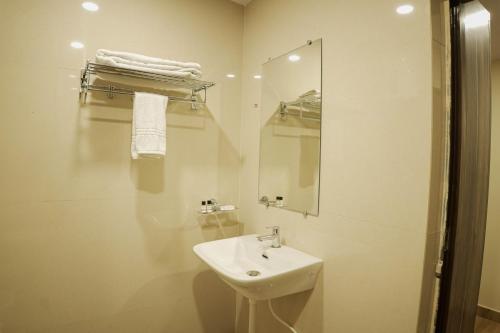 贾姆谢德布尔Hotel Grand Residency的白色的浴室设有水槽和镜子
