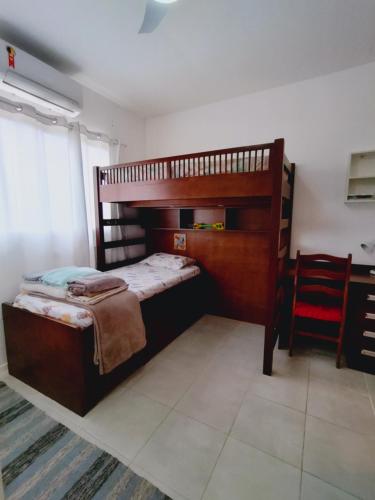 曼加拉蒂巴Casa com piscina privativa, 2 suítes, Sahy.的一间卧室设有两张双层床和一张红色椅子