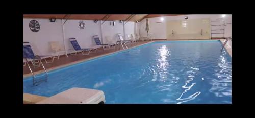 努瓦克肖特Florida Pool & Grill的大楼内带椅子的大型游泳池