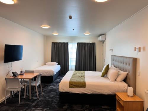 汉密尔顿Zeta Motel的酒店客房配有两张床和一张书桌