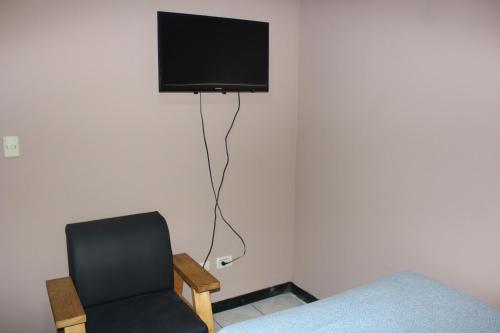 圣何塞多拉多酒店的一间房间,墙上有椅子和电视