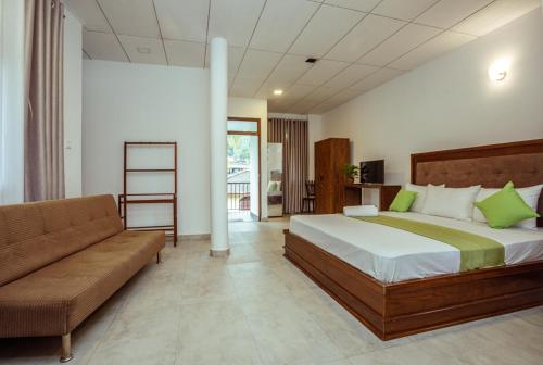 乌纳瓦图纳Villa Windfall Unawatuna的一间卧室配有一张大床和一张沙发
