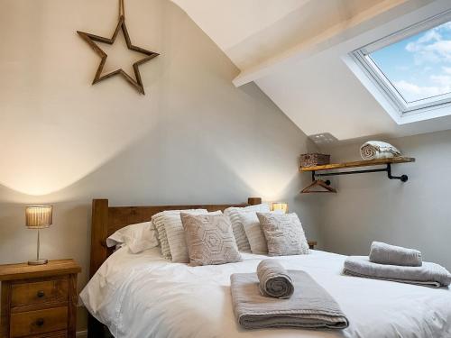 德朗菲尔德The Old Hayloft-uk39431的卧室配有一张带白色枕头的床,墙上有一星星。