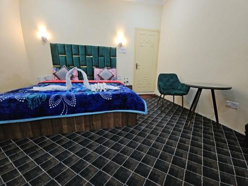 斯利那加Hotel Nouvella Residency的卧室配有1张床、1张桌子和1把椅子