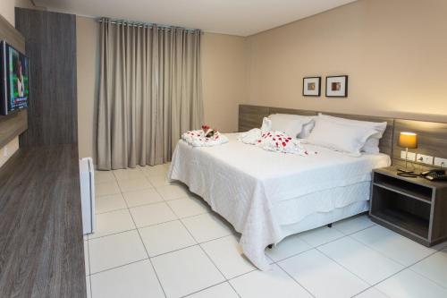 托里塔马Toritama Golden Hotel的卧室配有带鲜花的白色床