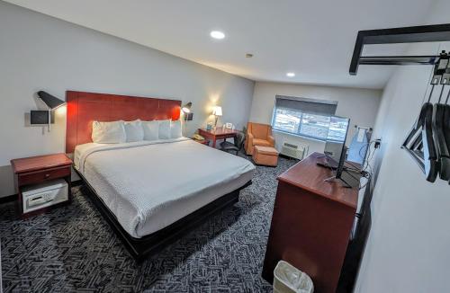 弗拉格斯塔夫弗拉格斯塔夫戴斯酒店的酒店客房设有一张大床和一张书桌。