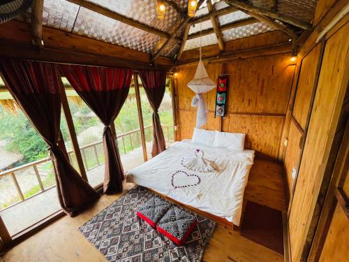 Pu LuongCuisine Garden的木制客房内的一间卧室,配有一张床