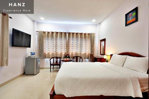 胡志明市HANZ Hoang Hoang Hotel Ben Thanh的酒店客房配有一张床铺和一张桌子。