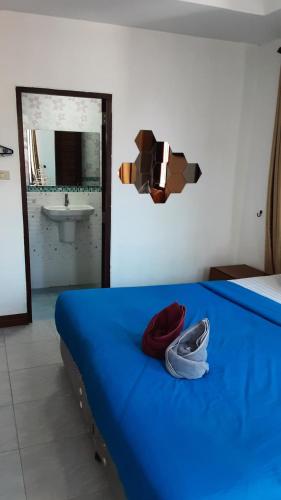 沙美岛可卡维村2@可萨梅特经济型酒店的一间卧室配有蓝色的床和水槽
