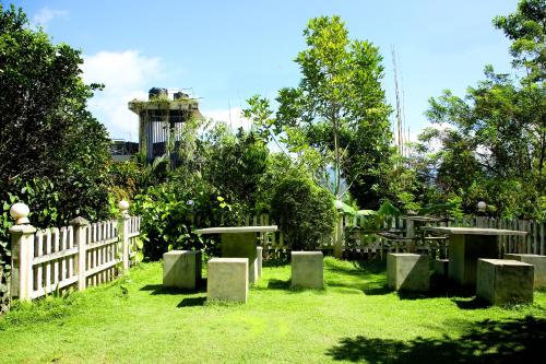 埃拉Ella Sanron guest & Ayurvedic Spa的花园,花园内有白色的栅栏和桌子,