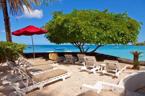 佩雷贝勒海滩俱乐部公寓式酒店的海滩上的一组躺椅和遮阳伞