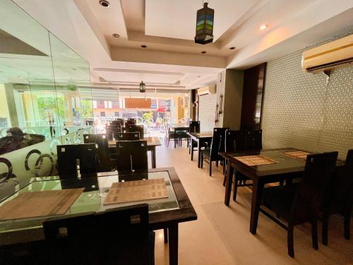 哈里瓦The Rio Lodge, Haridwar的餐厅内带桌椅的用餐室