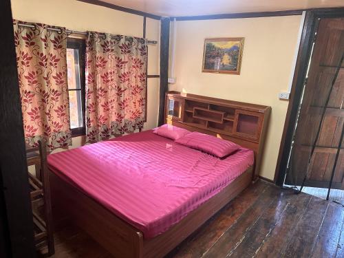 罗勇NADOHN2 Nai Fan Homestay的一间卧室配有一张带粉红色床单的大床