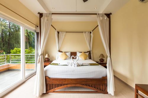 象岛一米阳光精品海滩Spa度假村的一间卧室设有一张天蓬床和一个阳台