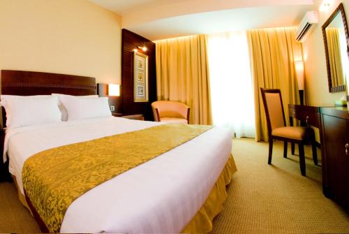 哥打京那巴鲁Celyn Hotel City Mall的酒店客房设有一张大床和一张书桌。