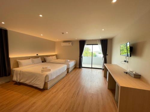 北碧V1 boutique hotel的酒店客房设有两张床和一台平面电视。