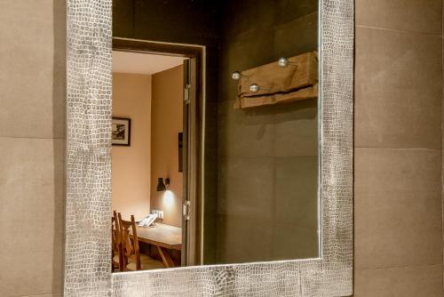 塔那那利佛Nosy Manga - Hotel Ivato Airport的镜子在浴室里,在房间里设有桌子