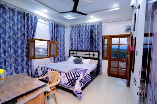 乌代浦Bhagora CJMA Home Stay/Villa的一间卧室配有一张带蓝色窗帘的床和一扇窗户