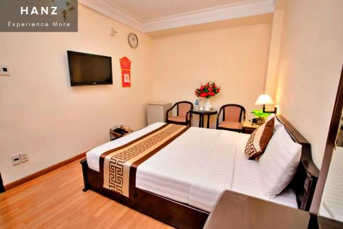 胡志明市HANZ Thanh Thu Hotel的一间酒店客房,配有一张床和一台电视