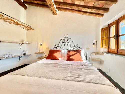 卢卡FRONTE MURA LUCCA - Parcheggio - WiFi Il CORTIGIANO的一间卧室配有一张带橙色枕头的大床