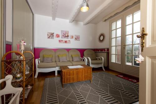 欧巴涅GITE HISTOIRE DE FAMILLE的客厅配有沙发和两把椅子