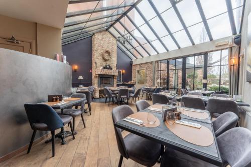 波佩林赫Maison de la Paix的餐厅设有桌椅和玻璃天花板