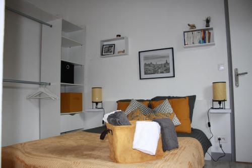 米洛Dolce Vita Millau的一间卧室配有带橙色枕头的床