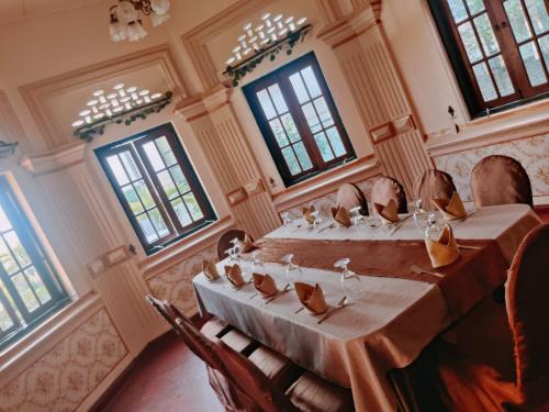 库鲁内格勒Grand Colonial Viveka的客房设有带椅子和窗户的长桌。