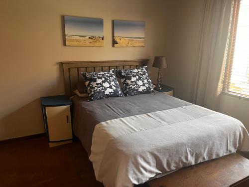 肯普顿帕克Villa 28的卧室配有一张床,墙上挂有两张照片
