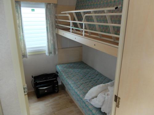 弗雷瑞斯REGENCY HOLIDAY Tour Opérateur dans Camping 5 étoiles Frejus, Cote d'Azur的小型客房配有双层床和双层床。