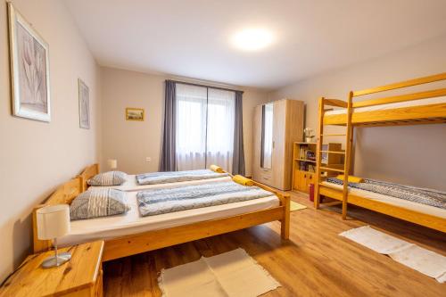 VasvárBoglárka Vendégház的一间卧室配有一张大床和两张双层床。