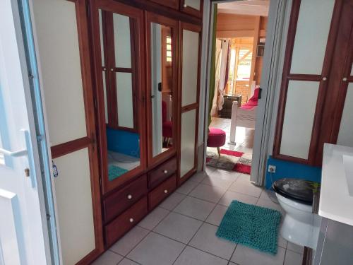 Rivière-PiloteJoli appartement的一间带卫生间和木制橱柜的浴室