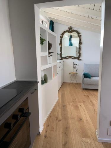 萨沃纳Via Pia 29-7的客厅设有白色的墙壁、木地板和镜子