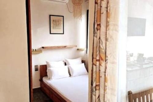 AndjamenBungalow Ramena beach Antsiranana的卧室配有带白色枕头的床和窗户。