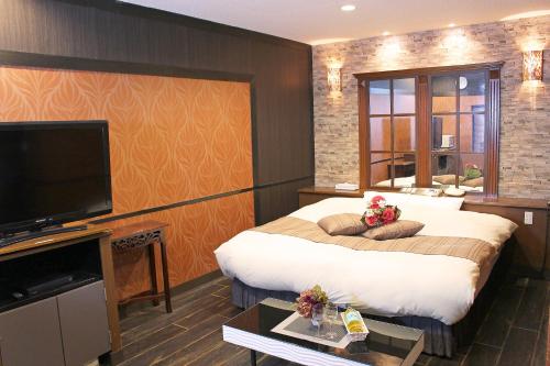 嬉野市パルアネックス鹿島店的一间酒店客房,配有一张大床和一台平面电视