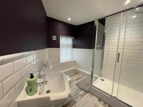 New MillsPeak District Stay Stylish for 2 Pass the Keys的白色的浴室设有水槽和淋浴。