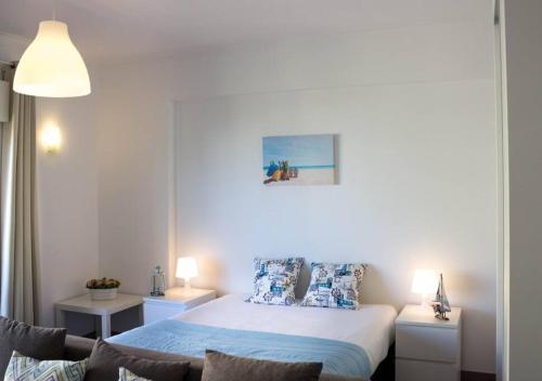 波尔蒂芒Casa dos Arcos BeachStudio by CC 904的一间卧室配有一张带蓝色床单和枕头的床。