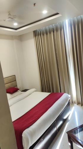 齐拉克普尔Hotel Urban Blueberry的一间卧室配有床和带窗帘的窗户