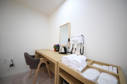 昌原市HARU Hotel的客房配有带摄像头和毛巾的书桌。