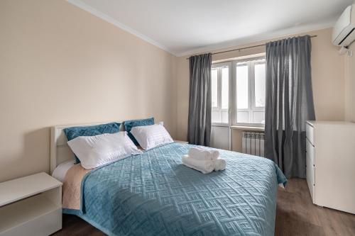 阿拉木图Two Bedroom Apartment In The Center of Almaty的一间卧室配有一张床,床上有毛巾