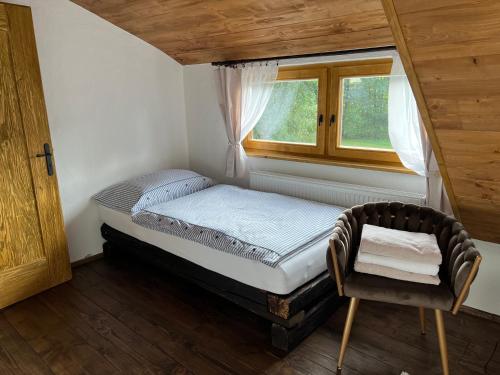 赫林斯科Hamerská chaloupka的一间小卧室,配有床和窗户