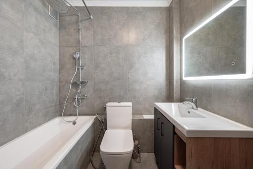 阿拉木图Two Bedroom Apartment In The Center of Almaty的浴室配有卫生间、盥洗盆和浴缸。