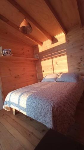 库雷尼佩Cabañas Orca Lodge Norte vista panoramica的小木屋内一间卧室,配有一张床
